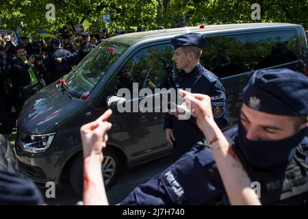 Warschau, Polen. 09.. Mai 2022. Während der Demonstration zeigen die Demonstranten auf das Auto, das die Delegation der russischen Botschaft trägt. Hunderte von Ukrainern und polnischen Aktivisten protestierten auf einem Warschauer Friedhof vor Soldaten der Roten Armee, die während des Zweiten Weltkriegs starben Der russische Botschafter in Polen, Sergej Andreev, wurde von Demonstranten, die gegen den Krieg in der Ukraine waren, bei einer jährlichen Veranstaltung zum Tag des Sieges zum Gedenken an das Ende des Zweiten Weltkriegs mit roter Farbe angestrichen Botschafter Sergej Andreew kam am Tag des Sieges auf dem sowjetischen Soldatenfriedhof an, um Blumen zu legen, aber der Diplomat und seine Delegation waren gezwungen, t zu verlassen Stockfoto