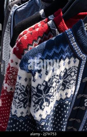 Handgefertigte skandinavische Wolljacke für Damen, Pullover im norwegischen Stil in allen möglichen Farben und Mustern, in einem Marktstand unter freiem Himmel Stockfoto