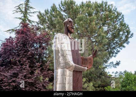 Metallische Statue eines alten Musikers, der seine Harfe im Stadtpark von Katerini City, Griechenland, hält Stockfoto