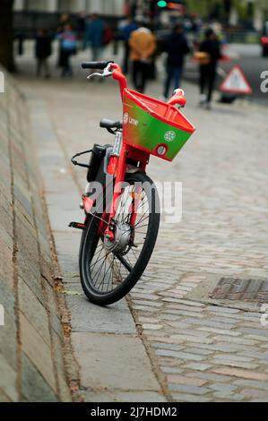 07. Mai 2022 - londonuk : ein einzelnes E-Bike steht auf dem londoner Bürgersteig mit verschwommenem Hintergrund Stockfoto