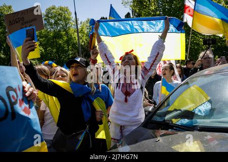 Warschau, Polen. 09.. Mai 2022. Frauen, die mit ukrainischen Flaggen gewickelt sind, rufen Slogans auf die russische Delegation, die versuchte, einen Trauerkranz zum Mausoleum sowjetischer Soldaten in Warschau zu bringen. Am 77.. Jahrestag des Sieges der Roten Armee über Nazi-Deutschland traten ukrainische Aktivisten auf dem sowjetischen Soldatenfriedhof in Warschau auf, als sie gegen die russische Invasion in der Ukraine protestierten. Aktivisten verboten der russischen Delegation unter der Leitung von Sergej Andreev, dem Botschafter der Russischen Föderation in Polen, den Eintritt in den Friedhof. Während dieses Versuchs wurden Diplomaten von der Ukrai mit gefälschtem Blut übergossen Stockfoto