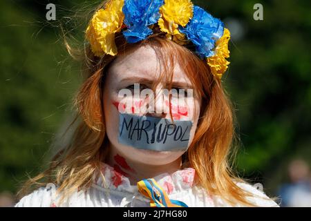 Warschau, Polen. 09.. Mai 2022. Ein Protestler mit mit Klebeband versiegelten Lippen nimmt an dem Protest Teil. Am 77.. Jahrestag des Sieges der Roten Armee über Nazi-Deutschland traten ukrainische Aktivisten auf dem sowjetischen Soldatenfriedhof in Warschau auf, als sie gegen die russische Invasion in der Ukraine protestierten. Aktivisten verboten der russischen Delegation unter der Leitung von Sergej Andreev, dem Botschafter der Russischen Föderation in Polen, den Eintritt in den Friedhof. Während dieses Versuchs wurden Diplomaten von ukrainischen Aktivisten mit gefälschtem Blut übergossen. Kredit: SOPA Images Limited/Alamy Live Nachrichten Stockfoto