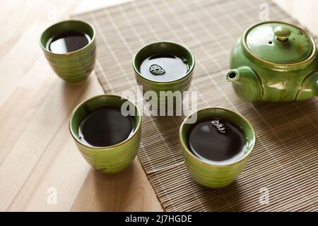 Grüne Teekannen und Teetassen. Heißes Getränk auf Holztisch. Bio-Produkt aus der Natur für Gesundheit Stockfoto