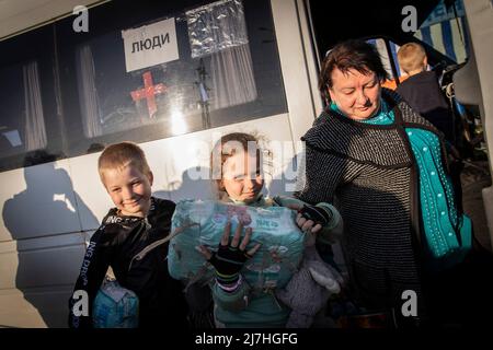 Saporischschja, Ukraine. 08.. Mai 2022. Igor (L1, 8) und Sophia (L2, 7) steigen mit ihren Eltern aus, nachdem sie aus Cherson in Zaporizhia angekommen sind. Inmitten der verschärften Kriegskrise in der Südost-Ukraine wurden Millionen ukrainischer Familien aus den Kriegsgebieten und von Russland kontrollierten Gebieten in die von der Ukraine kontrollierten Gebiete Saporischschja evakuiert. Es wird angenommen, dass seit Beginn des Konflikts mehr als 11 Millionen Menschen aus ihrer Heimat in der Ukraine geflohen sind, 7,7 Millionen Menschen sind in ihrer Heimat vertrieben worden. Kredit: SOPA Images Limited/Alamy Live Nachrichten Stockfoto