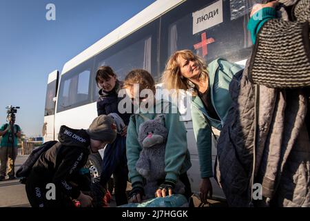 Igor (L1, 8) und Sophia (L2, 7) steigen mit ihren Eltern aus, als sie nach der Ankunft in Saporischschja von Cherson in andere Städte abreisen. Inmitten der verschärften Kriegskrise in der Südost-Ukraine wurden Millionen ukrainischer Familien aus den Kriegsgebieten und von Russland kontrollierten Gebieten in die von der Ukraine kontrollierten Gebiete Saporischschja evakuiert. Es wird angenommen, dass seit Beginn des Konflikts mehr als 11 Millionen Menschen aus ihrer Heimat in der Ukraine geflohen sind, 7,7 Millionen Menschen sind in ihrer Heimat vertrieben worden. Stockfoto