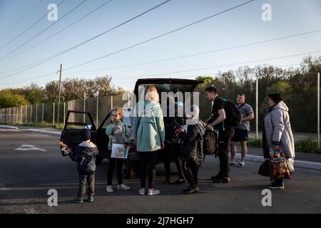 Sophia (L1, 7), Igor (L3, 8) Sergei (L4, 2,5) packen ihre Habseligkeiten mit ihren Eltern in das Auto, als sie von Cherson aus in andere Städte fahren, nachdem sie in Saporizhia angekommen sind. Inmitten der verschärften Kriegskrise in der Südost-Ukraine wurden Millionen ukrainischer Familien aus den Kriegsgebieten und von Russland kontrollierten Gebieten in die von der Ukraine kontrollierten Gebiete Saporischschja evakuiert. Es wird angenommen, dass seit Beginn des Konflikts mehr als 11 Millionen Menschen aus ihrer Heimat in der Ukraine geflohen sind, 7,7 Millionen Menschen sind in ihrer Heimat vertrieben worden. Stockfoto