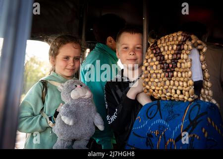 Sophia (L1, 7) und Igor (L2, 8) posieren für ein Foto, während sie mit ihren Eltern und ihrem kleinen Bruder aus dem Auto aussteigen, nachdem sie aus Cherson in Zaporizhia angekommen sind. Inmitten der verschärften Kriegskrise in der Südost-Ukraine wurden Millionen ukrainischer Familien aus den Kriegsgebieten und von Russland kontrollierten Gebieten in die von der Ukraine kontrollierten Gebiete Saporischschja evakuiert. Es wird angenommen, dass seit Beginn des Konflikts mehr als 11 Millionen Menschen aus ihrer Heimat in der Ukraine geflohen sind, 7,7 Millionen Menschen sind in ihrer Heimat vertrieben worden. Stockfoto