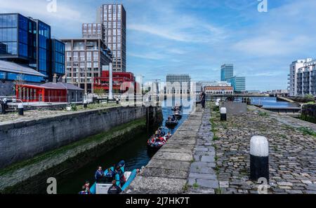 Eine Gruppe kleiner Boote, die den Fluss Liffey verlassen und in die Buckingham Lock in Ringsend, Dublin, Irland, auf dem Weg zum Grand Canal Dock und weiter fahren. Stockfoto