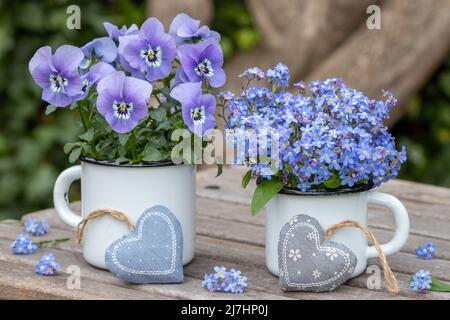 Strauß von Vergiss mich nicht Blumen und Viola Blume in Vintage Emaille Tassen Stockfoto