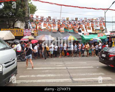 Caloocan, Philippinen. 09.. Mai 2022. Die philippinischen Wähler warten vor der Grundschule von Gomburza, um ihre Stimmen abzugeben. 65,7 Millionen Filipinos strömen in ihre jeweiligen Bezirke, um ihr Wahlrecht auszuüben. Sie werden ihre Stimmen abgeben, um zu entscheiden, wer der nächste Präsident sein wird. Außerdem werden sie ihre Stimmzettel für Exekutive und Legislative auf nationaler, provinzieller und lokaler Ebene ausfüllen. Kredit: SOPA Images Limited/Alamy Live Nachrichten Stockfoto