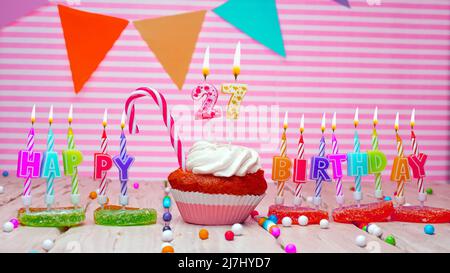 Happy Birthday Karte auf einem rosa Hintergrund, mit einer Figur in einem Cupcake. Schöner Happy Birthday Hintergrund mit einer Nummer mit brennender Kerze. Festlich Stockfoto