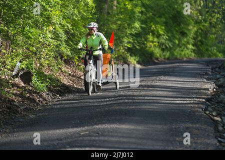 USA - 9. Mai 2022: Flora Hillman von Bloomfield nutzt ihr E-Fahrrad mit einem Call-Trailer im Schlepptau, um die Straßen im Westen von Loudoun zu säubern. Sie w Stockfoto