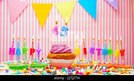 Alles Gute zum Geburtstag. Auf einem rosa Hintergrund ein Happy Birthday Gruß für ein Kind. Cupcakes mit rosa Creme und brennender Kerze. Speicherplatz kopieren. Stockfoto