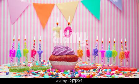 Alles Gute zum Geburtstag. Auf einem rosa Hintergrund ein Happy Birthday Gruß für ein Kind. Cupcakes mit rosa Creme und brennender Kerze. Speicherplatz kopieren. Stockfoto