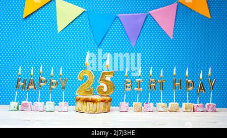 Alles gute zum Geburtstag aus Kerzenbuchstaben auf blauem Hintergrund mit weißem Tupfen-Kopierraum. Alles gute zum Geburtstag Cupcake mit brennender goldener Kerze Stockfoto