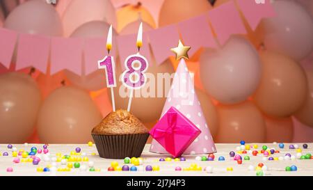 Ballondekorationen und eine Geburtstagskerze mit einer Nummer in einem Kuchen. Alles gute zum Geburtstag Grüße in rosa Farben für ein Mädchen, Platz kopieren. Muffin Stockfoto