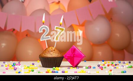 Ballondekorationen und eine Geburtstagskerze mit einer Nummer in einem Kuchen. Alles gute zum Geburtstag Grüße in rosa Farben für ein Mädchen, Platz kopieren. Muffin Stockfoto