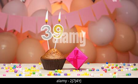 Ballondekorationen und eine Geburtstagskerze mit einer Nummer in einem Kuchen. Alles gute zum Geburtstag Grüße in rosa Farben für ein Mädchen, Platz kopieren. Muffin Stockfoto