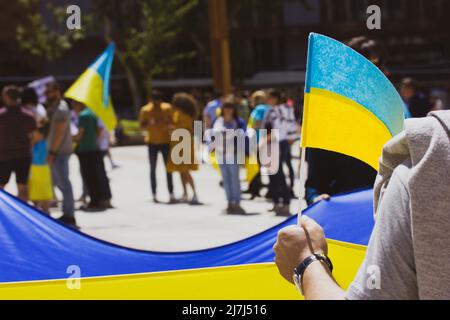 Menschen bei Kundgebung zur Unterstützung der von Russland betroffenen Ukraine. Patrioten mit gelb blauen ukrainischen Fahnen. Stoppen Sie Putin, Hände weg von der Ukraine, retten Sie Mariupol. Pro Stockfoto