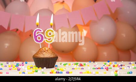 Ballondekorationen und eine Geburtstagskerze mit einer Nummer in einem Kuchen. Alles gute zum Geburtstag Grüße in rosa Farben für ein Mädchen, Platz kopieren. Muffin Stockfoto