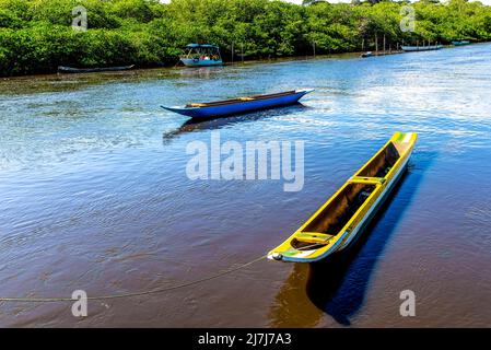 Zwei Fischerkanus und ein Boot auf dem Fluss Jaguaripe in Maragogipino, Bahia, Brasilien. Stockfoto