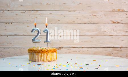 Alles gute zum Geburtstag silberne Ziffern auf weißen Brettern Hintergrund kopieren Raum. Schöne Geburtstagskarte mit einem Cupcake mit brennender Kerze Stockfoto