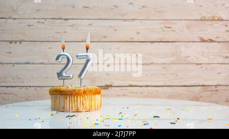 Alles gute zum Geburtstag silberne Ziffern auf weißen Brettern Hintergrund kopieren Raum. Schöne Geburtstagskarte mit einem Cupcake mit brennender Kerze Stockfoto