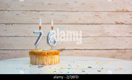 Alles gute zum Geburtstag silberne Ziffern auf weißen Brettern Hintergrund kopieren Raum. Schöne Geburtstagskarte mit einem Cupcake mit brennender Kerze Stockfoto
