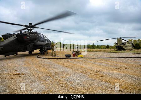 Apache-Piloten von 2. Squadron, 17. Kavallerieregiment, 101. Combat Aviation Brigade, 101. Airborne Division (Air Assault) erhalten während einer „Fat Cow“-Mission im Mai 4 in Fort Knox, Ky, Treibstoff von der Rückseite eines chinook-Hubschraubers. „Fat Cow“-Missionen sind ein vor Ort beschleunigter Betankungsprozess, der es chinook-Hubschraubern ermöglicht, Kraftstoff für andere Hubschrauber in der Einheit bereitzustellen, während sie noch hinter feindlichen Linien arbeiten. (USA Armeefoto von Sgt. Jeremy Lewis, 40. Public Affairs Detachment) Stockfoto