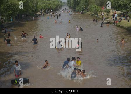 Lahore, Pakistan. 08.. Mai 2022. Die pakistanischen Menschen kühlen sich in einem Kanal während des heißen Wetters in lahore ab. Im März und April versengte extreme Hitze den Großteil Indiens und des benachbarten Pakistans, wodurch über eine Milliarde Menschen Temperaturen von weit über 40 Grad Celsius (104 Fahrenheit) ausgesetzt waren. Die wärmsten Monate des Jahres stehen noch bevor. (Foto von Rana Sajid Hussain/Pacific Press) Quelle: Pacific Press Media Production Corp./Alamy Live News Stockfoto