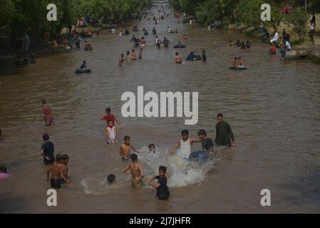 Lahore, Pakistan. 08.. Mai 2022. Die pakistanischen Menschen kühlen sich in einem Kanal während des heißen Wetters in lahore ab. Im März und April versengte extreme Hitze den Großteil Indiens und des benachbarten Pakistans, wodurch über eine Milliarde Menschen Temperaturen von weit über 40 Grad Celsius (104 Fahrenheit) ausgesetzt waren. Die wärmsten Monate des Jahres stehen noch bevor. (Foto von Rana Sajid Hussain/Pacific Press) Quelle: Pacific Press Media Production Corp./Alamy Live News Stockfoto