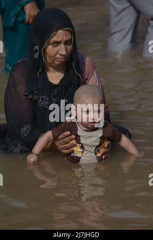 Lahore, Pakistan. 08.. Mai 2022. Die pakistanischen Menschen kühlen sich in einem Kanal während des heißen Wetters in lahore ab. Im März und April versengte extreme Hitze den Großteil Indiens und des benachbarten Pakistans, wodurch über eine Milliarde Menschen Temperaturen von weit über 40 Grad Celsius (104 Fahrenheit) ausgesetzt waren. Die wärmsten Monate des Jahres stehen noch bevor. (Foto von Rana Sajid Hussain/Pacific Press) Quelle: Pacific Press Media Production Corp./Alamy Live News Stockfoto