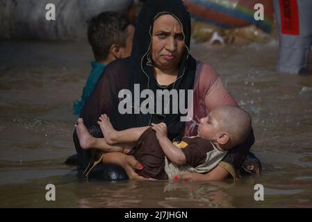 Lahore, Pakistan. 08.. Mai 2022. Die pakistanischen Menschen kühlen sich in einem Kanal während des heißen Wetters in lahore ab. Im März und April versengte extreme Hitze den Großteil Indiens und des benachbarten Pakistans, wodurch über eine Milliarde Menschen Temperaturen von weit über 40 Grad Celsius (104 Fahrenheit) ausgesetzt waren. Die wärmsten Monate des Jahres stehen noch bevor. (Foto von Rana Sajid Hussain/Pacific Press) Quelle: Pacific Press Media Production Corp./Alamy Live News Stockfoto