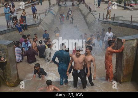 Lahore, Pakistan. 08.. Mai 2022. Die pakistanischen Menschen kühlen sich in einem Kanal während des heißen Wetters in lahore ab. Im März und April versengte extreme Hitze den Großteil Indiens und des benachbarten Pakistans, wodurch über eine Milliarde Menschen Temperaturen von weit über 40 Grad Celsius (104 Fahrenheit) ausgesetzt waren. Die wärmsten Monate des Jahres stehen noch bevor. (Foto von Rana Sajid Hussain/Pacific Press) Quelle: Pacific Press Media Production Corp./Alamy Live News Stockfoto