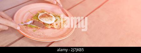 Mann, der benediktei isst. Eigelb brach. Kochen von Kartoffelpfannkuchen. Abendessen mit Gabel und Messer. Cafe vegetarische Küche. Hausgemachtes, köstliches Essen. Essen im Freien. Gesunder Brunch Stockfoto