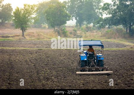 TIKAMGARH, MADHYA PRADESH, INDIEN - 02. MAI 2022: Indischer Landwirt, der mit Traktor in der Landwirtschaft arbeitet. Stockfoto