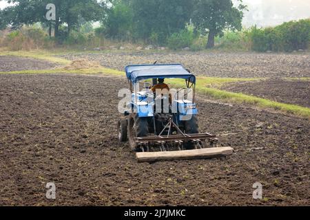 TIKAMGARH, MADHYA PRADESH, INDIEN - 02. MAI 2022: Indischer Landwirt, der mit Traktor in der Landwirtschaft arbeitet. Stockfoto