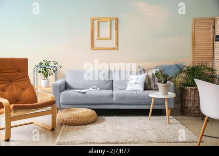Interieur des Wohnzimmers mit stilvollen Möbeln und lackierten hellen Wänden Stockfoto