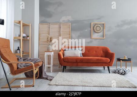 Interieur des Wohnzimmers mit stilvollen Möbeln und lackierten grauen Wänden Stockfoto