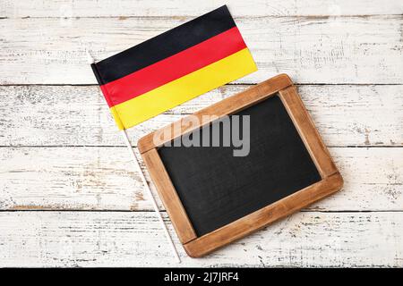 Flagge Deutschlands und Tafel auf hellem Holzhintergrund Stockfoto