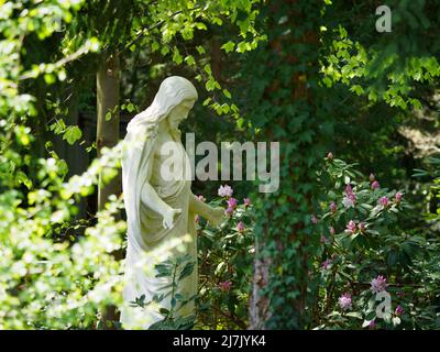 Stahnsdorf, Deutschland. 02.. Mai 2022. Im südwestlichen Kirchhof der Berliner Stadtsynode steht eine Christusstatue unter den Bäumen. Der Friedhof südwestlich von Berlin ist mit mehr als 200 Hektar der zweitgrößte in Deutschland. Aufgrund seines Waldcharakters und seiner vielen historischen Grabstätten ist der Südwestkirchhof ein beliebtes Touristenziel. Für die Erhaltung des kulturell und kunsthistorisch bedeutsamen Ortes wurde 2000 ein Förderverein gegründet. Quelle: Soeren Stache/dpa/ZB/dpa/Alamy Live News Stockfoto