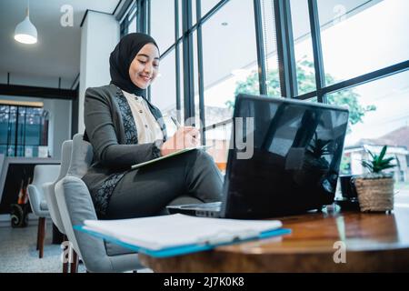 Junge Geschäftsfrau muslimische Frau, die in ihrem Büro arbeitet Stockfoto