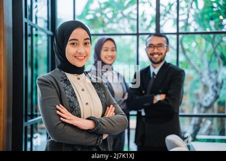 muslimische Geschäftsfrau, die vor ihrem Team steht Stockfoto