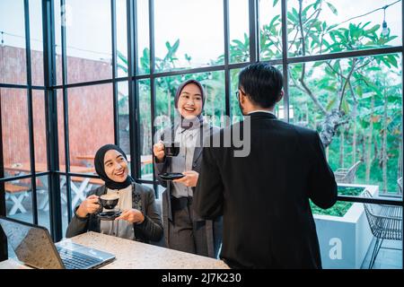 muslimisches Team, das während des Treffens im Büro ein Gespräch führt Stockfoto
