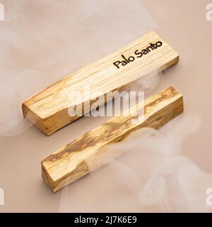 Stäbchen eines Palo Santo Baumes auf beigem Hintergrund. Natürliches Räucherwerk des heiligen Baumes aus Südamerika. Aromatherapie, eine Anti-Stress-Behandlung Stockfoto