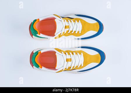 Paar stilvolle bunte Jugend-Sneaker auf weißem Hintergrund, Sport trendige Schuhe, Draufsicht Stockfoto