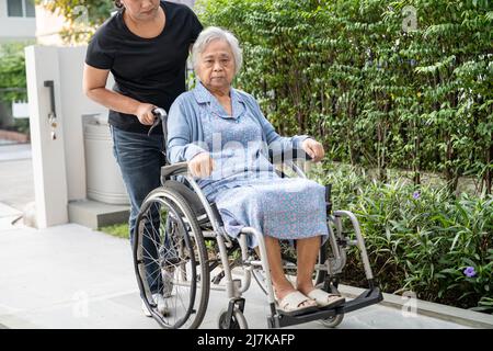 Pflegerin Hilfe und Pflege Asiatische ältere oder ältere alte Dame Frau Patientin sitzt auf Rollstuhl auf Rampe auf Krankenpflege Station, gesund starke medizinische Stockfoto