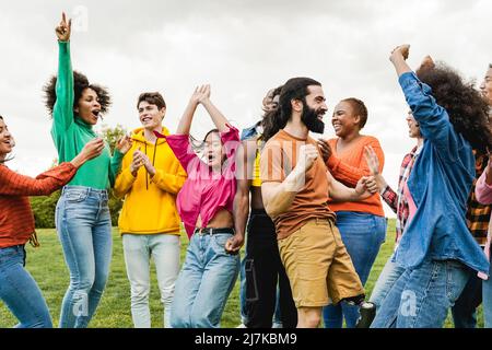 Multiethnische Gruppe von Freunden, die Spaß haben, gemeinsam im Freien während der Sommerferien zu tanzen - Fokus auf Mann mit Beinprothese Stockfoto