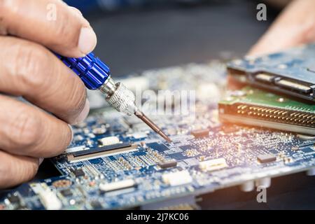 Techniker repariert die Leiterplatteninnenseite mit einem Lötkolben. Integrated Circuit. Das Konzept von Daten, Hardware, Techniker und Technolo Stockfoto