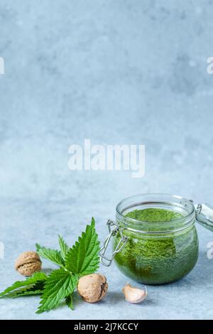 Vegetarisches Nessel-, Knoblauch- und Walnusspesto. Glas hausgemachtes Nesselpesto mit Walnüssen und Knoblauch. Veganes Brennnesselpesto Stockfoto